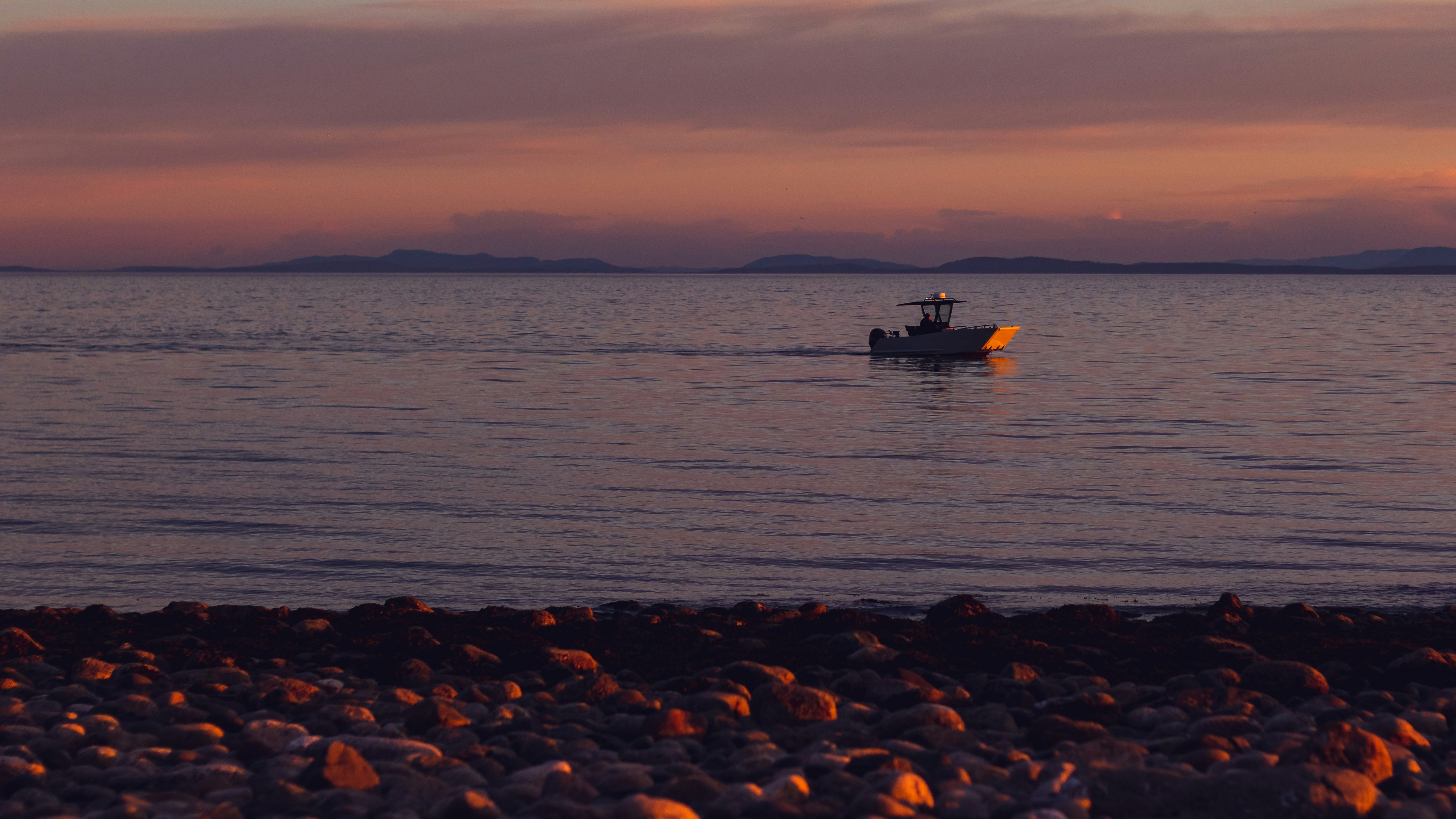 silhouette of boat on sea during sunset